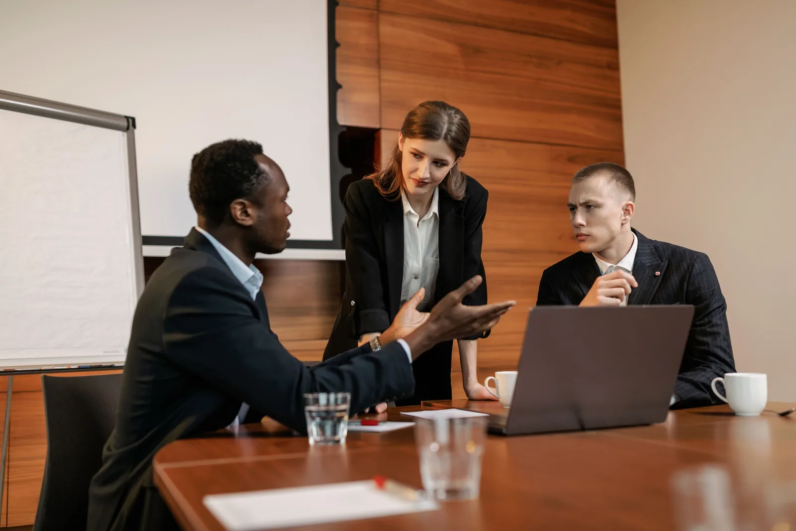 Three business professionals discussing an opportunity around a boardroom table