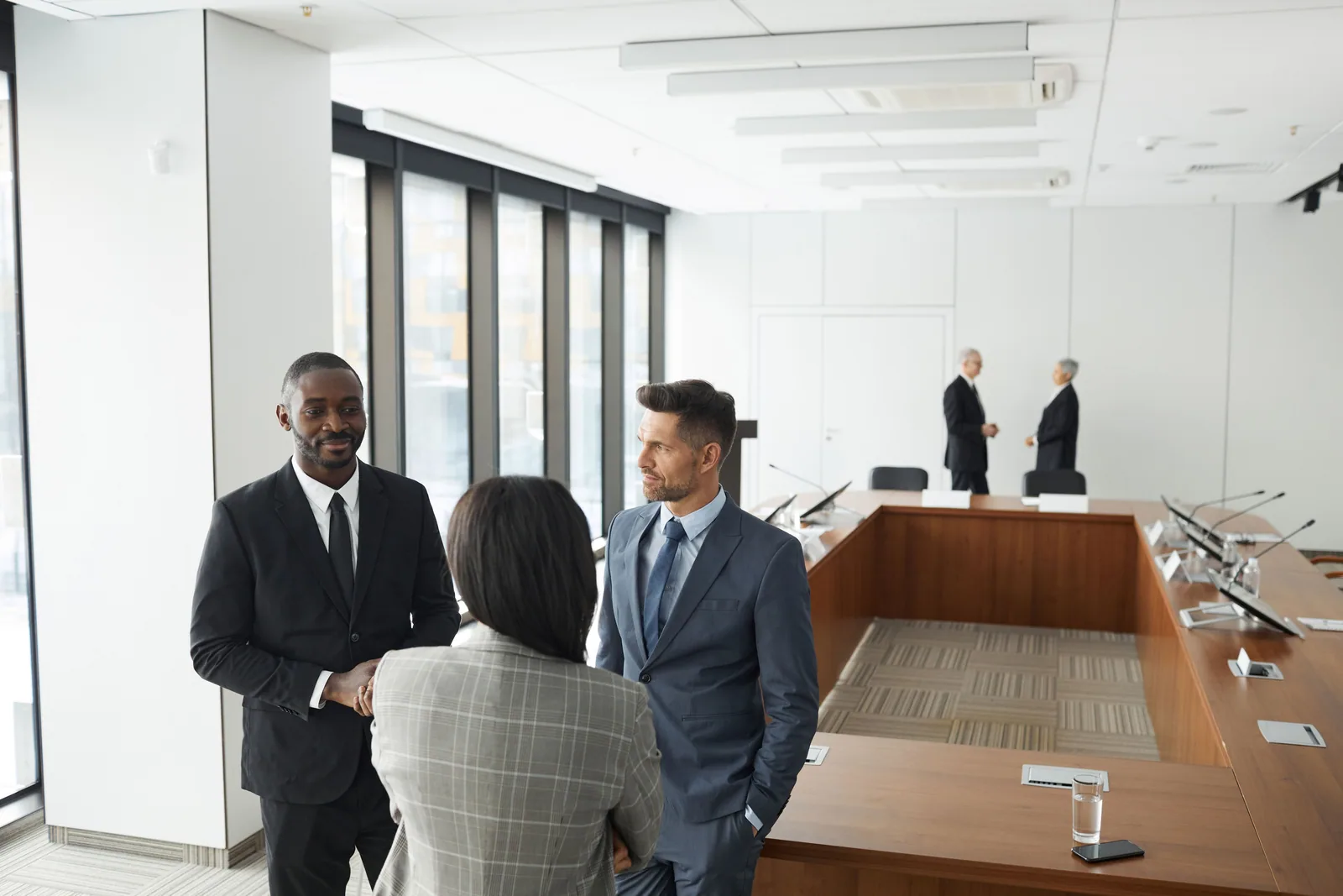 Three professionals meeting in a formal conference room